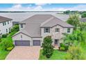 Attractive two-story home with a three-car garage, stone accents, and lush green landscaping at 16689 Broadwater Ave, Winter Garden, FL 34787