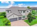 Beautiful home with a paved driveway, three-car garage, stone accents, and well-manicured landscaping at 16689 Broadwater Ave, Winter Garden, FL 34787