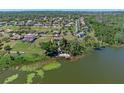 Aerial view of home on the lake with boat dock and wooded property at 16752 Caravaggio Loop, Montverde, FL 34756