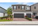 Modern home showcases a two-car garage, neutral exterior, and is enhanced by a brick driveway and tidy landscaping at 3173 Riverboat Way, Oviedo, FL 32765