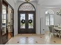 Inviting foyer featuring a decorative front door, tile flooring, and views into the dining room at 3340 Fernlake Pl, Longwood, FL 32779