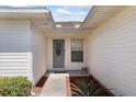 The front entryway with white trim, a storm door, and a small garden at 3748 Innisbrook Dr, Lakeland, FL 33810