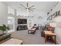 Cozy living room featuring vaulted ceilings, a modern fan, plush furniture, and ample natural light at 442 Troon Cir, Davenport, FL 33897