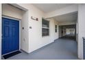 Apartment hallway with bright blue door and exterior access, showcasing apartment complex at 4751 Clock Tower Dr # 203, Kissimmee, FL 34746