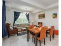 Open living room with comfortable seating, elegant decor, and a dining area with a wooden table set for dinner at 4751 Clock Tower Dr # 203, Kissimmee, FL 34746