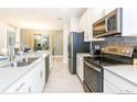 Contemporary kitchen with stainless steel appliances, white cabinetry, and an open view to the dining area at 4962 Windermere Ave, Kissimmee, FL 34746