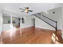 Bright living room with hardwood floors, decorative columns, and a staircase at 5456 Crepe Myrtle Cir, Kissimmee, FL 34758