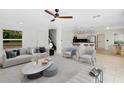 Bright, open-concept living space with modern furnishings, tile flooring, and views to the kitchen and staircase at 608 Abaco Ct, Kissimmee, FL 34746