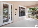 Inviting covered porch features a decorative glass front door, neighborhood views, and neutral flooring at 6475 New Independence Pkwy, Winter Garden, FL 34787