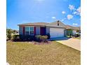 Inviting single-Gathering home with a two-car garage, vibrant red shutters, and a lush green lawn at 992 Serchio St, Haines City, FL 33844