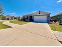 Charming home boasts a two-car garage and manicured front lawn, enhancing its curb appeal and neighborhood charm at 992 Serchio St, Haines City, FL 33844