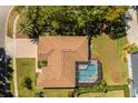 Aerial view of a home with a screened-in pool, brick driveway, and lush landscaping at 10337 Pointview Ct, Orlando, FL 32836