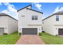 Modern two-story home with brick driveway, gray garage door, and well-maintained landscaping at 10372 Austrina Oak Loop, Winter Garden, FL 34787