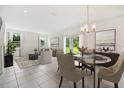 Inviting dining area adjacent to living room with stylish lighting and views of the backyard at 1124 Patriot Loop, Haines City, FL 33844