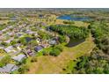 Sprawling aerial view of a residential community with lush greenery, ponds, and lakes nearby at 13552 Dornoch Dr, Orlando, FL 32828