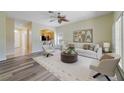 Bright living room featuring modern neutral décor, an eye catching ceiling fan, and a view of the kitchen at 13850 Mirror Lake Dr, Orlando, FL 32828