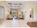 A sunny living room with high ceilings, archways, french doors, and a beautiful tile and wood floor at 1649 Kersley Cir, Lake Mary, FL 32746