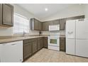 A well-lit kitchen showcases stainless steel appliances, mocha cabinets, and light countertops at 1740 Efland Ter, Deltona, FL 32738