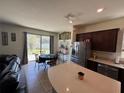 Open kitchen boasts stainless steel appliances, an island, and sliding glass doors to the backyard at 1825 Cayman Cove Cir, St Cloud, FL 34772