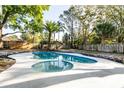 Backyard view featuring a private pool, well-maintained landscaping, and a classic wooden fence at 2952 Ashwood Ct, Apopka, FL 32703