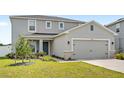 Two-story home features gray stucco, stone accents, a gray garage door, and a well-manicured lawn at 3936 Fescue St, Clermont, FL 34714