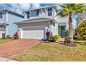 Charming two-story home with a brick driveway, tidy lawn, and a beautiful palm tree accenting the entrance at 3964 Lightning Ct, Sanford, FL 32773