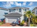 Charming two-story home with a brick driveway and a beautiful palm tree accenting the facade at 3964 Lightning Ct, Sanford, FL 32773