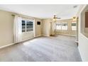 Bright and airy living room with neutral carpet, ceiling fan, and view to the dining area at 46 Morning Glory Dr, Debary, FL 32713