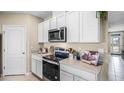 Bright kitchen featuring stainless steel appliances, white cabinets, and durable countertops at 5223 Ligonberry St, Lakeland, FL 33811