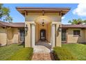 Grand front door with ornate ironwork, flanked by columns and sconce lighting at 5400 Kenmore Ln, Orlando, FL 32839