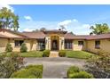 Elegant home exterior with a columned entrance, brick accents, and manicured landscaping at 5400 Kenmore Ln, Orlando, FL 32839