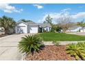 Inviting single-story home with a two-car garage, mature landscaping, and a well-maintained lawn at 5600 Revelwood Loop, Winter Park, FL 32792