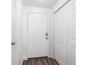 Image shows an entryway with a white door and wood laminate floors at 6412 Queens Borough Ave # 215, Orlando, FL 32835