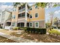 Beautiful three-story condo with yellow siding, white trim, and screened in patios at 6412 Queens Borough Ave # 215, Orlando, FL 32835