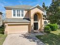 Inviting two-story home featuring an arched entryway and a two-car garage at 643 Willett Dr E, Winter Garden, FL 34787