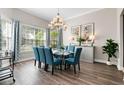 Elegant dining room with modern chandelier, seating for six, and natural light from large windows at 7419 Gathering Ct, Reunion, FL 34747