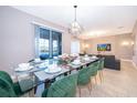 Open concept dining area with seating for eight, view of the living room, and sliding glass door at 830 Sticks, Davenport, FL 33896