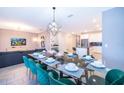 Elegant dining room with seating for eight, modern chandelier, and adjacent living and kitchen spaces at 830 Sticks, Davenport, FL 33896