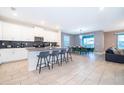 Spacious kitchen with white cabinetry, stainless steel appliances, a breakfast bar, and tiled floors at 830 Sticks, Davenport, FL 33896