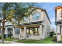 Attractive two-story house featuring a welcoming porch, a tidy lawn, and tree in a quiet residential neighborhood at 9149 Grand Island Way, Winter Garden, FL 34787