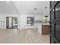 Bright and airy living room and kitchen featuring modern flooring, white walls, and stylish black-trimmed windows at 1022 Glenharbor Cir, Winter Garden, FL 34787