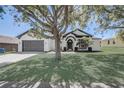 Beautiful single-story home with lush green lawn, mature tree, and welcoming entrance at 116 Brookshire Dr, Lake Wales, FL 33898