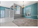 Elegant dining room with chandelier lighting, carpet, and a large window for natural light at 1601 Carillon Park Dr, Oviedo, FL 32765