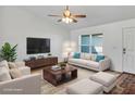Cozy living room features white walls, a plush couch with blue pillows, and a modern ceiling fan at 16171 Sw 44Th Cir, Ocala, FL 34473