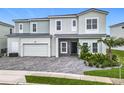 Well-maintained exterior featuring a two-car garage and a combination of siding and stucco finishes at 1739 Oak Blossom Dr, Davenport, FL 33837