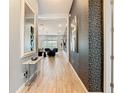 Hallway featuring tile flooring, modern patterned wallpaper, and a glimpse of the living space beyond at 1739 Oak Blossom Dr, Davenport, FL 33837