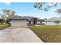 Attractive one-story home boasting a spacious driveway, a two-car garage, and an appealing facade at 205 Lori Ct, Umatilla, FL 32784