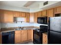 Galley kitchen featuring black appliances, wood cabinets, and laminate countertops at 225 E New Hampshire St # 20, Orlando, FL 32804