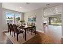 Inviting dining room with a glass table, hardwood floors, and a bright view through large windows at 2341 Oleander Rd, Deland, FL 32724