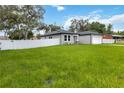 A well-maintained home showcasing lush green grass and a secure white fence at 2341 Oleander Rd, Deland, FL 32724